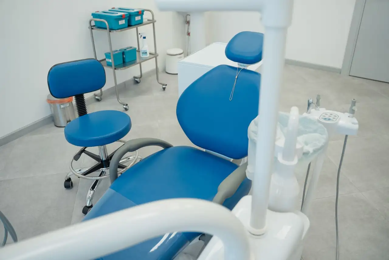 A clean and modern dental clinic featuring blue chairs and essential dental equipment.